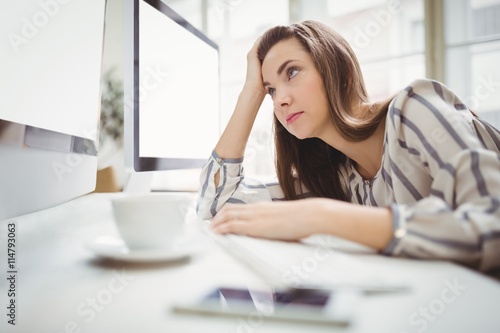 Businesswoman looking at computer in creative office