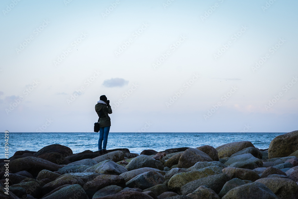 Happy woman photographing sea on the beach Happy woman photographing sea on the beach
