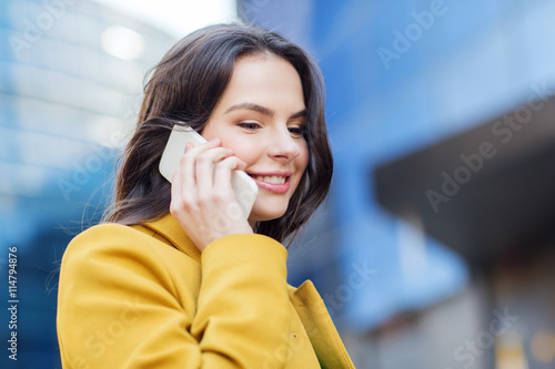 smiling young woman or girl calling on smartphone