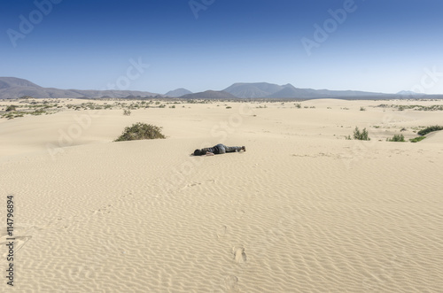 Woman fainted in desert sand.