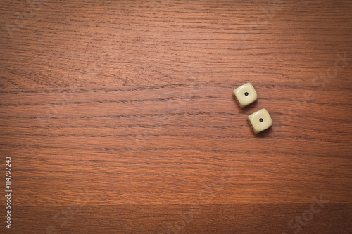 two dice on a wooden table value of one