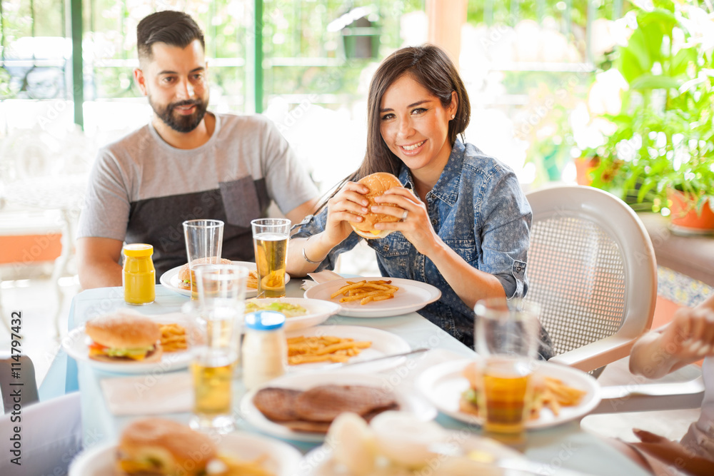 Young woman eating hamburger at a barbecue Young woman eating hamburger at a barbecue