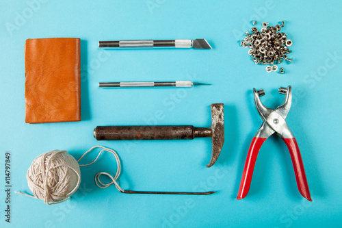 Working tools for embossed leather on brown background top view photo