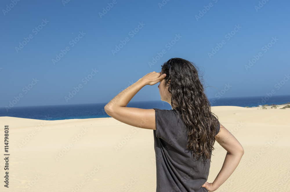 Rear View of brunette woman with her hand in her forehead lookin Rear View of brunette woman with her hand in her forehead lookin