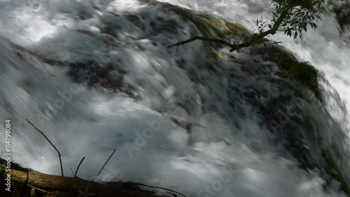 Zoom out of the small waterfall and then pan to right down the river photo