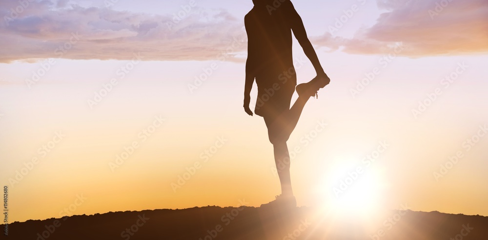 Composite image of sporty man stretching his leg