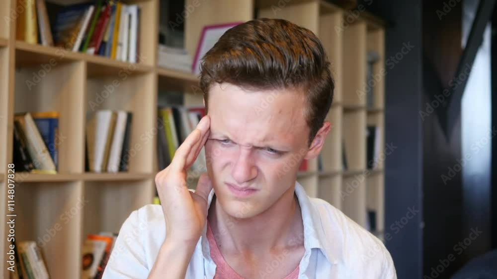 Feeling awful headache. Depressed young man touching his head with hands Feeling awful headache. Depressed young man touching his head with hands