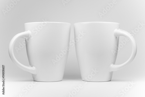 Fotografi Two white mugs in a mirrored arrangement .