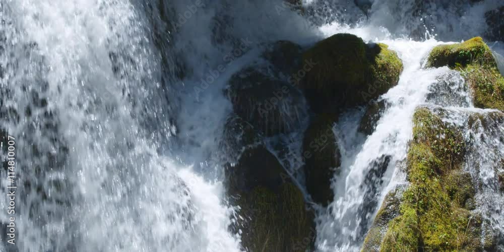 Close-up waterfall among mossy boulders in a forest stream Close-up waterfall among mossy boulders in a forest stream