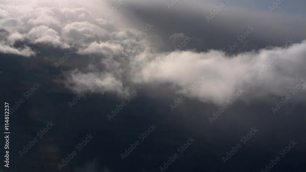 Tilting flight through wispy clouds at edge of gray cloud mass Tilting flight through wispy clouds at edge of gray cloud mass