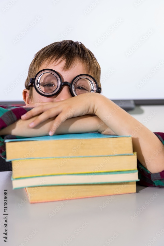 Boy leaning on books at table in classroom Boy leaning on books at table in classroom
