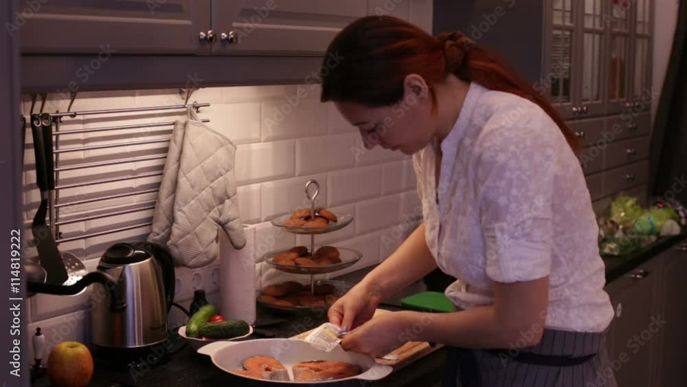 Woman Prepares Red Fish Salmon in the Kitchen Woman Prepares Red Fish Salmon in the Kitchen