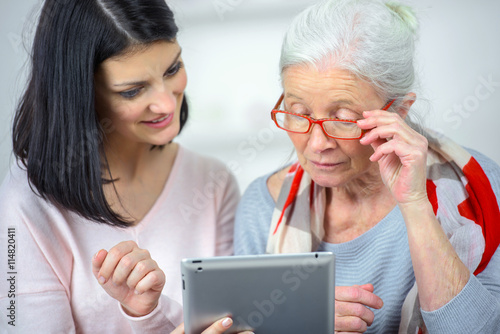Konstfotografi Helping old woman use a tablet computer