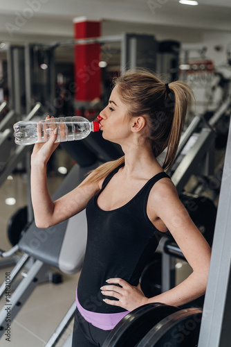 Beautiful blonde drinking water in the gym