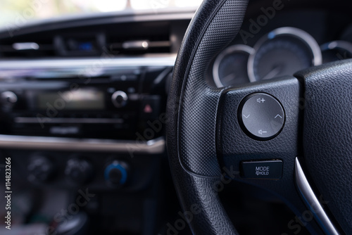 Audio control buttons on the steering wheel of a modern car © structuresxx