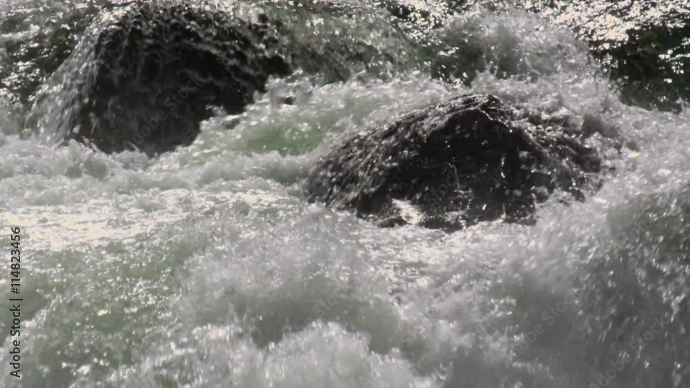 Close-up whitewater and rounded rocks in a river Close-up whitewater and rounded rocks in a river