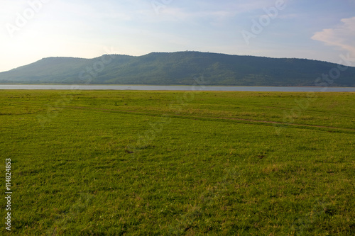 Landscape field of grass  sky and mountain.