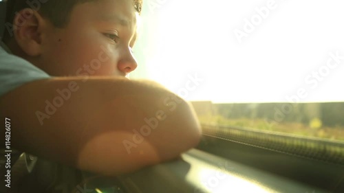 Little boy travelling in bus and looking through the window