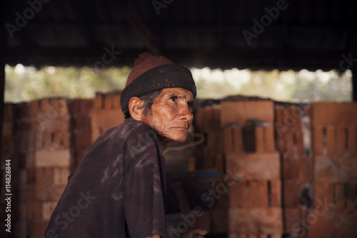 Old man worker resting after work hard in brickyard factory © prachid