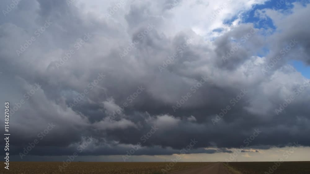 Time-lapse gray clouds rising over cropland and prairie Time-lapse gray clouds rising over cropland and prairie