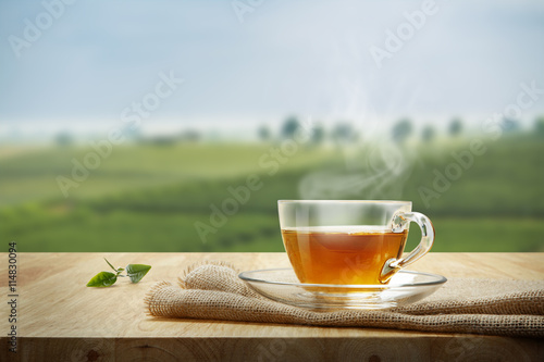 Tea cup with and tea leaf sacking on the wooden table and the te