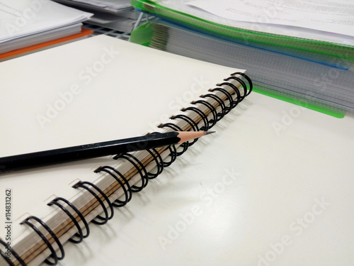 Black Pencil on  open Note book on  desk in traininig room photo