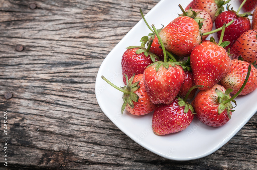 Small white filled with succulent juicy fresh ripe red strawberr Small white filled with succulent juicy fresh ripe red strawberr