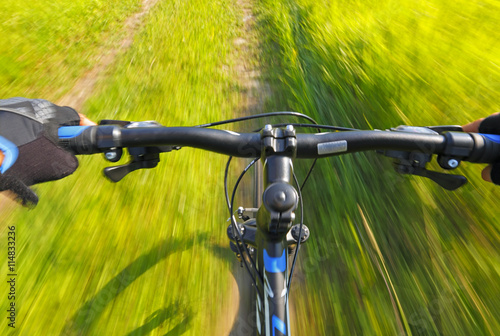 Fast motion mountain bike on a grassy road