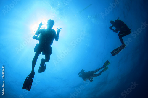 Scuba diving: group of divers silhouette with sun