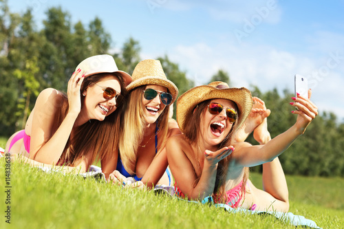 Group of women in bikin taking selfie outdoors © Kalim