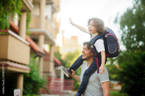 Little pupil sitting on the shoulders of his father.