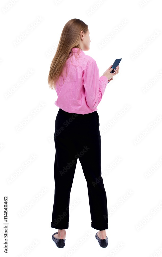 back view of standing young beautiful  woman  and using a mobile