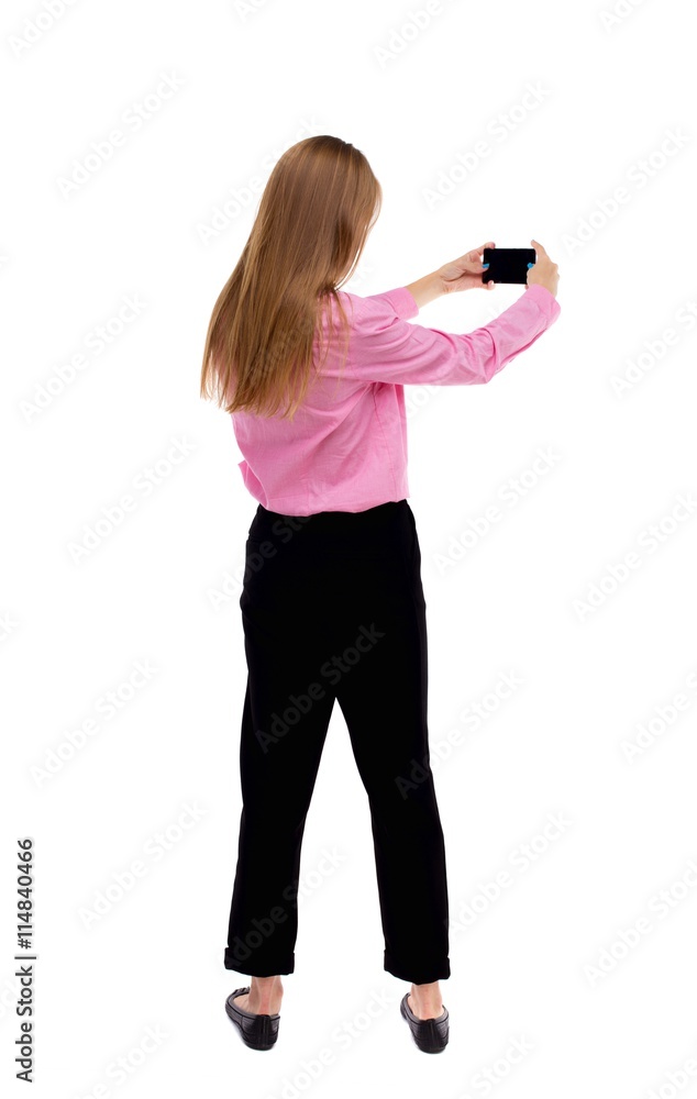 back view of standing young beautiful woman and using a mobile back view of standing young beautiful woman and using a mobile