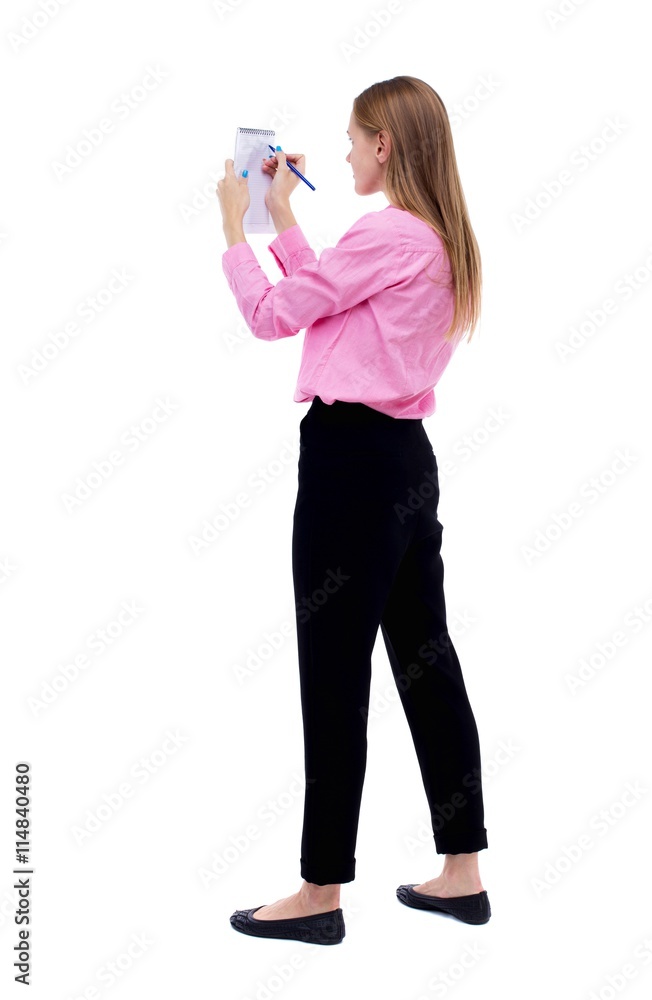 back view of stands woman takes notes in a notebook. girl watc back view of stands woman takes notes in a notebook. girl watc