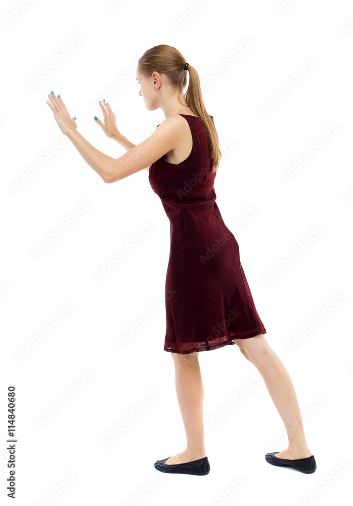 back view of woman pushes wall.