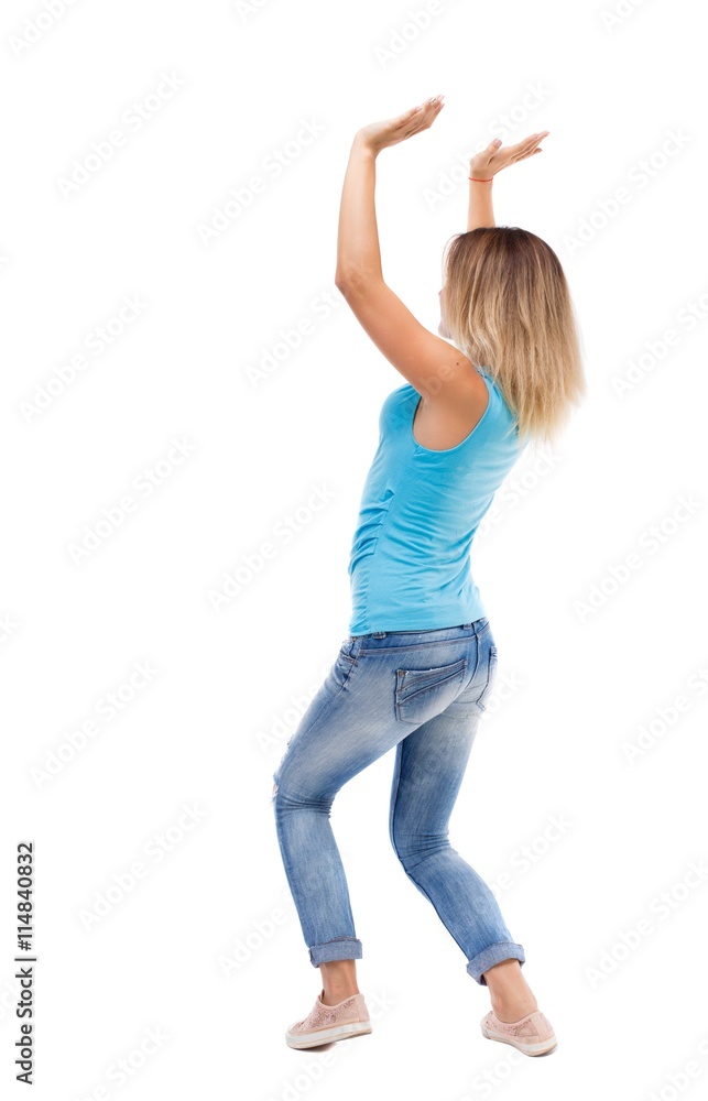 back view of woman protects hands from what is falling from abo back view of woman protects hands from what is falling from abo