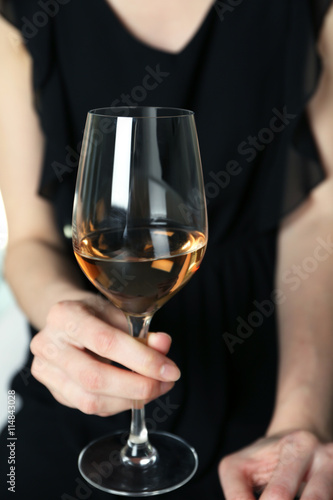 Woman holding glass of wine, closeup