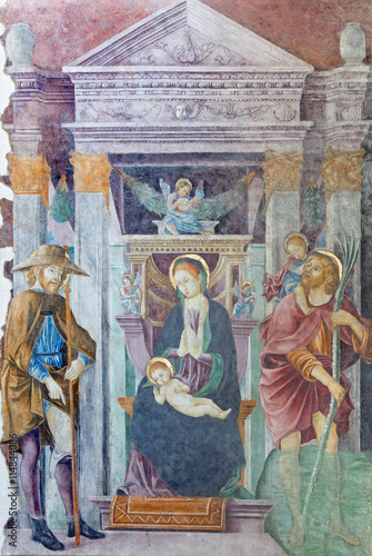 BRESCIA, ITALY - MAY 21, 2016: The fresco of Madonna with the St. Christopher and St. Roch in church Chiesa del Santissimo Corpo di Cristo by Paolo Caylina il Vecchio (cca 1501).