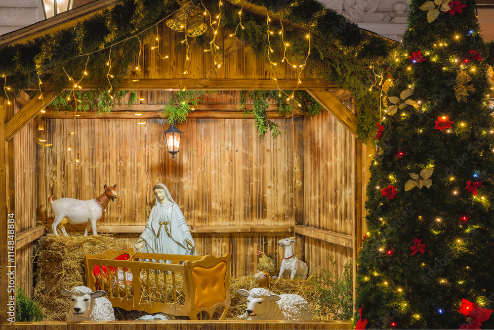 Fototapeta premium Nativity scene with Holy family of Joseph, Mary, baby Jesus Christ and sheep, holiday decorations in the Old Town in the magical city of Prague at night, Czech Republic