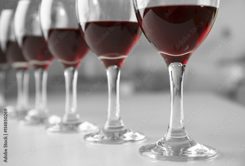 Glasses of red wine on white table closeup