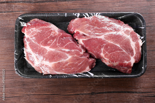 Packed pieces of pork meat on wooden background