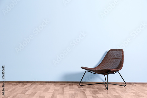 Empty room with wicker chair  on blue wall background © Africa Studio