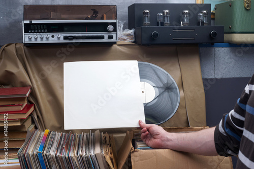 Retro styled image of a collection of old vinyl record lp's with sleeves on a wooden background. Browsing through vinyl records collection. Music background. Copy spase