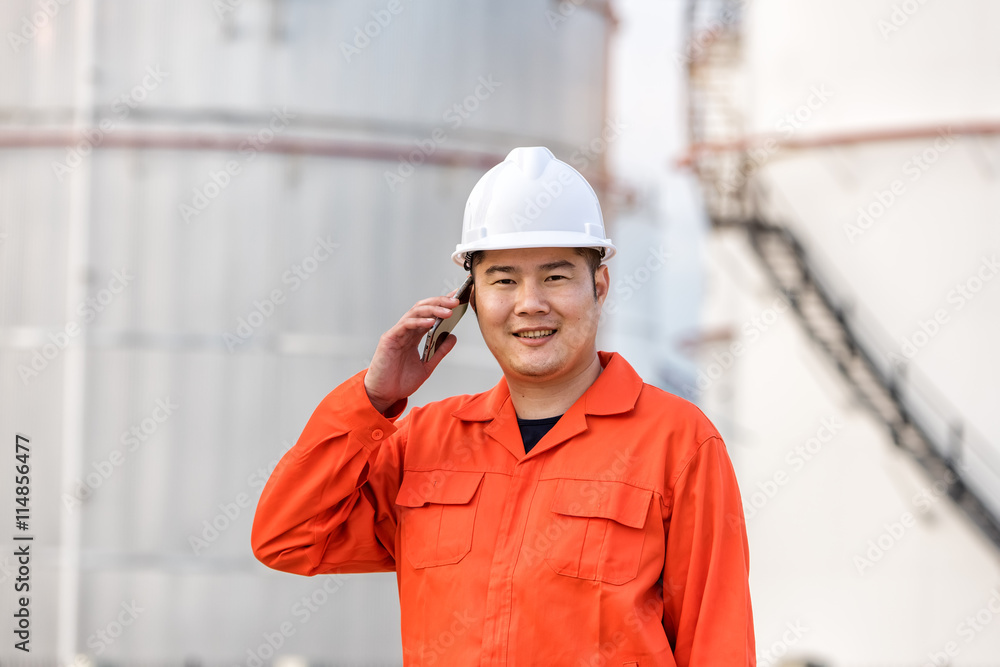 Portrait of a male of industrial engineer at work using phone in Portrait of a male of industrial engineer at work using phone in