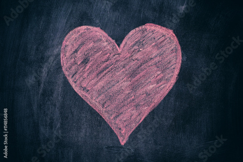 Pink heart shape on black chalkboard background