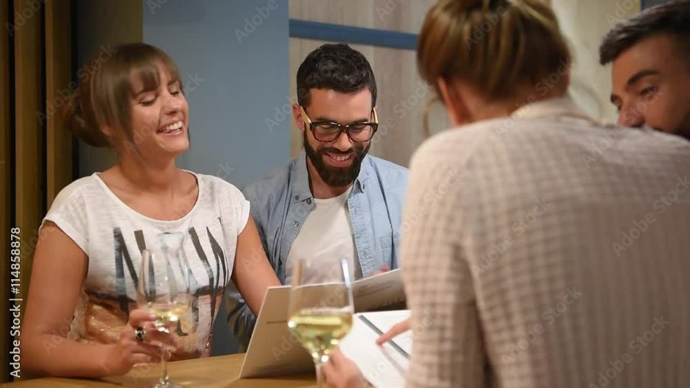 Trendy people in a restaurant looking at menu Trendy people in a restaurant looking at menu