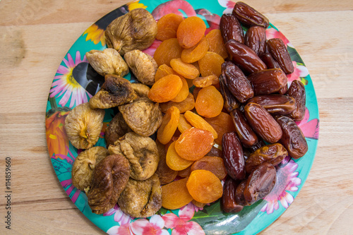 plate of tasty dried figs, apricots and dates photo