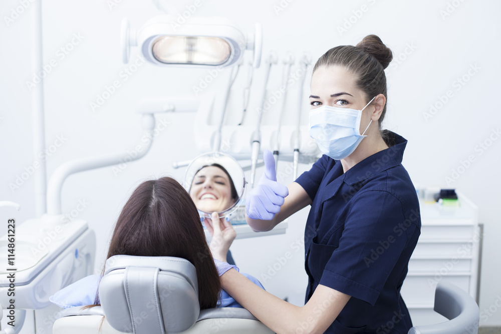 Obraz premium Beautiful woman patient having dental treatment at dentist's office. Woman visiting her dentist