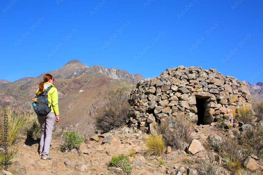 Tourist looking at pre-Incan round house named colca near Chivay