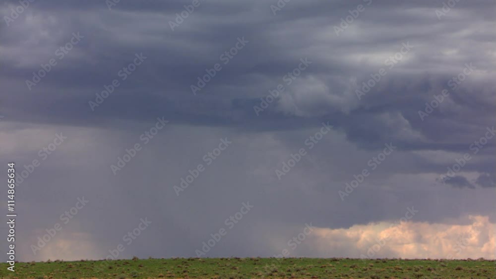Two bolts of lightning striking from dark cloud above green plain Two bolts of lightning striking from dark cloud above green plain